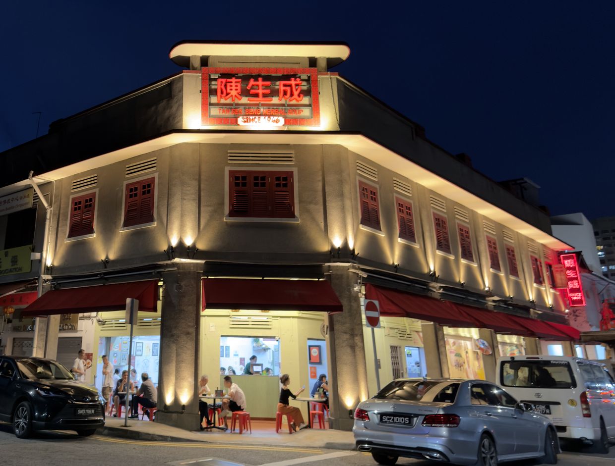 The same corner in April 2026 at night, after the facade was renewed
